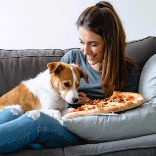 A Woman Cuddling with Her Puppy While Eating Pizza on the Couch